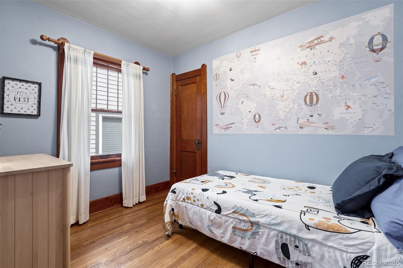1247 Harrison Street Denver, CO 80206 - Photo 16 of 50 a bedroom with a bed and wooden floor