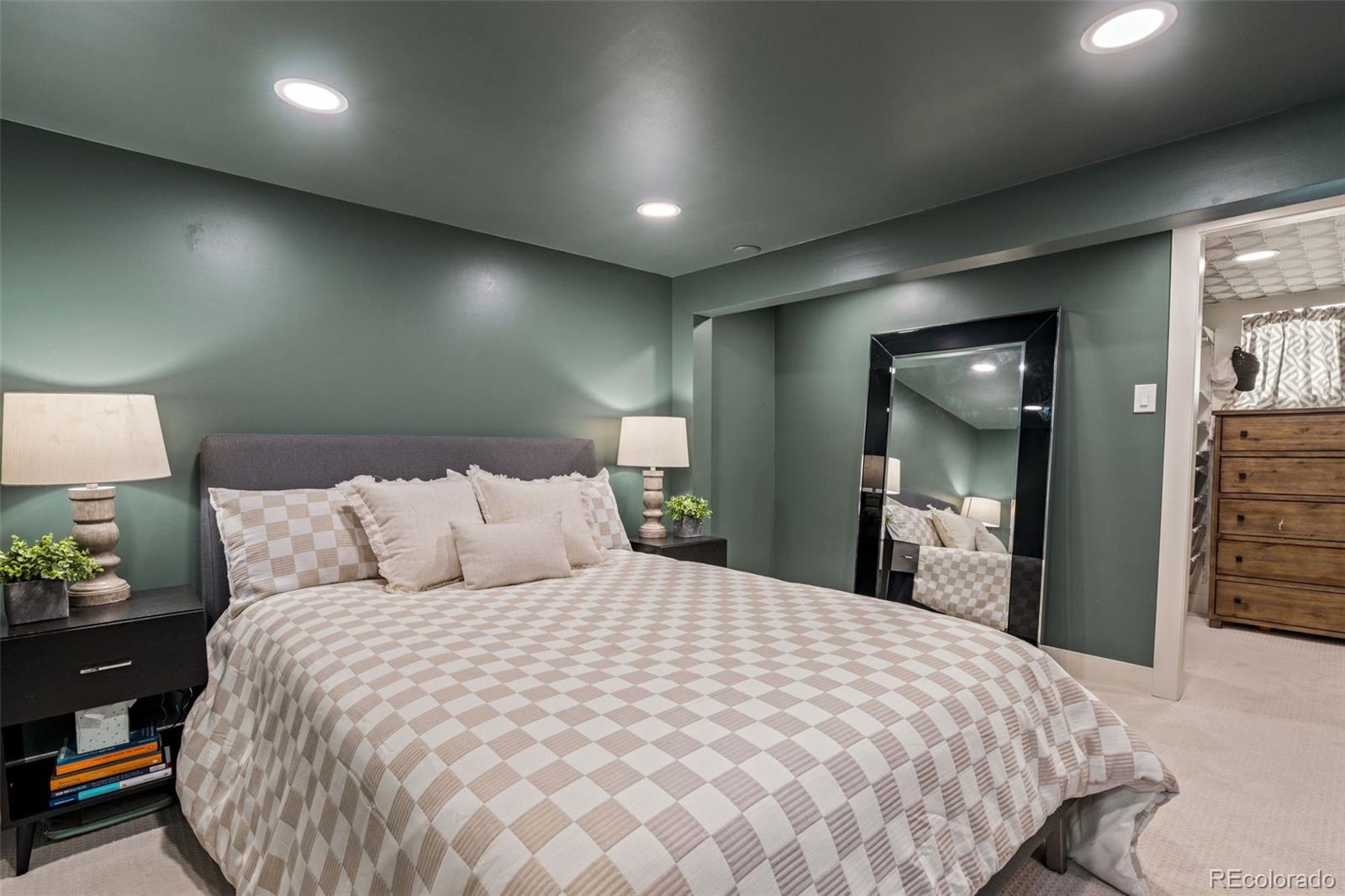1247 Harrison Street Denver, CO 80206 - Photo 30 of 50 a large bed sitting in a bedroom and a mirror