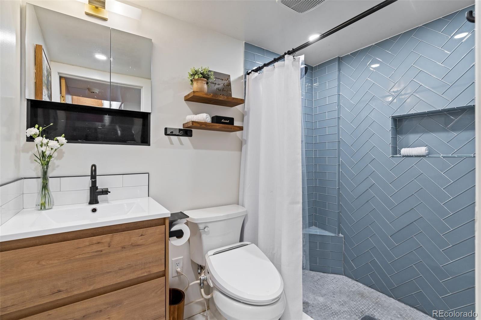 1247 Harrison Street Denver, CO 80206 - Photo 33 of 50 a bathroom with a sink a toilet and shower
