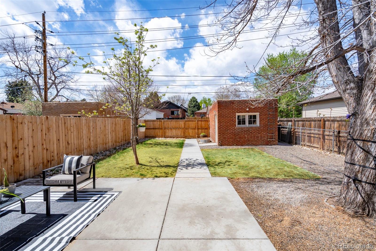 1247 Harrison Street Denver, CO 80206 - Photo 34 of 50 a view of backyard with table and chairs and wooden fence