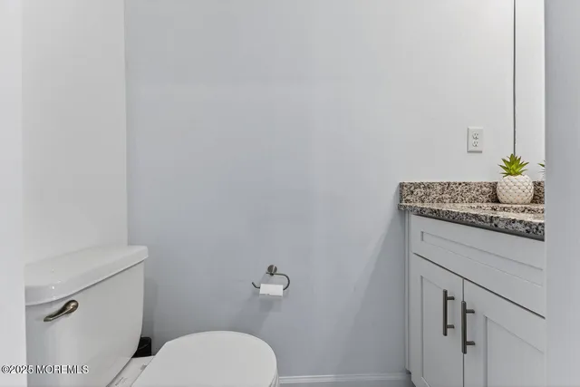 a bathroom with a granite countertop toilet and sink