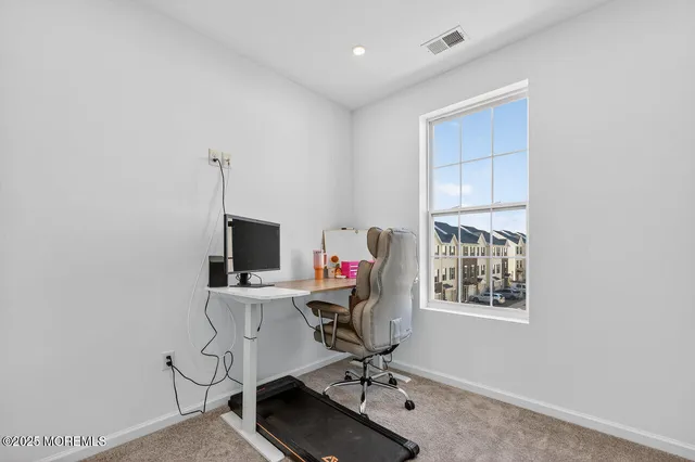 a view of a workspace with furniture and a window