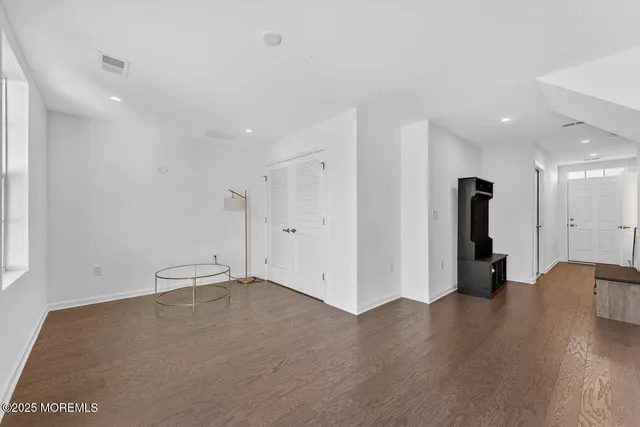 a view of empty room with wooden floor