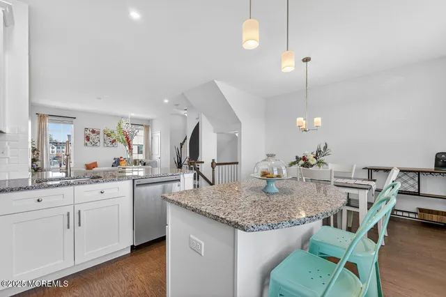 a kitchen with granite countertop kitchen island stainless steel appliances a sink and stove