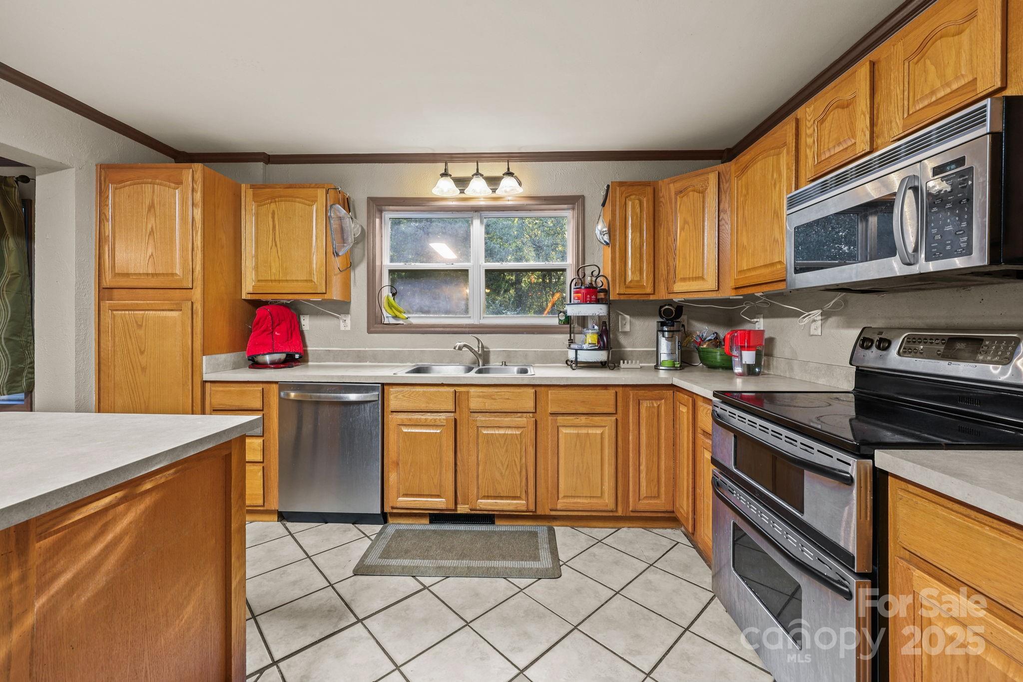 952 Flat Swamp Road Denton, NC 27239 - Photo 9 of 37 a kitchen with stainless steel appliances granite countertop a sink stove and cabinets