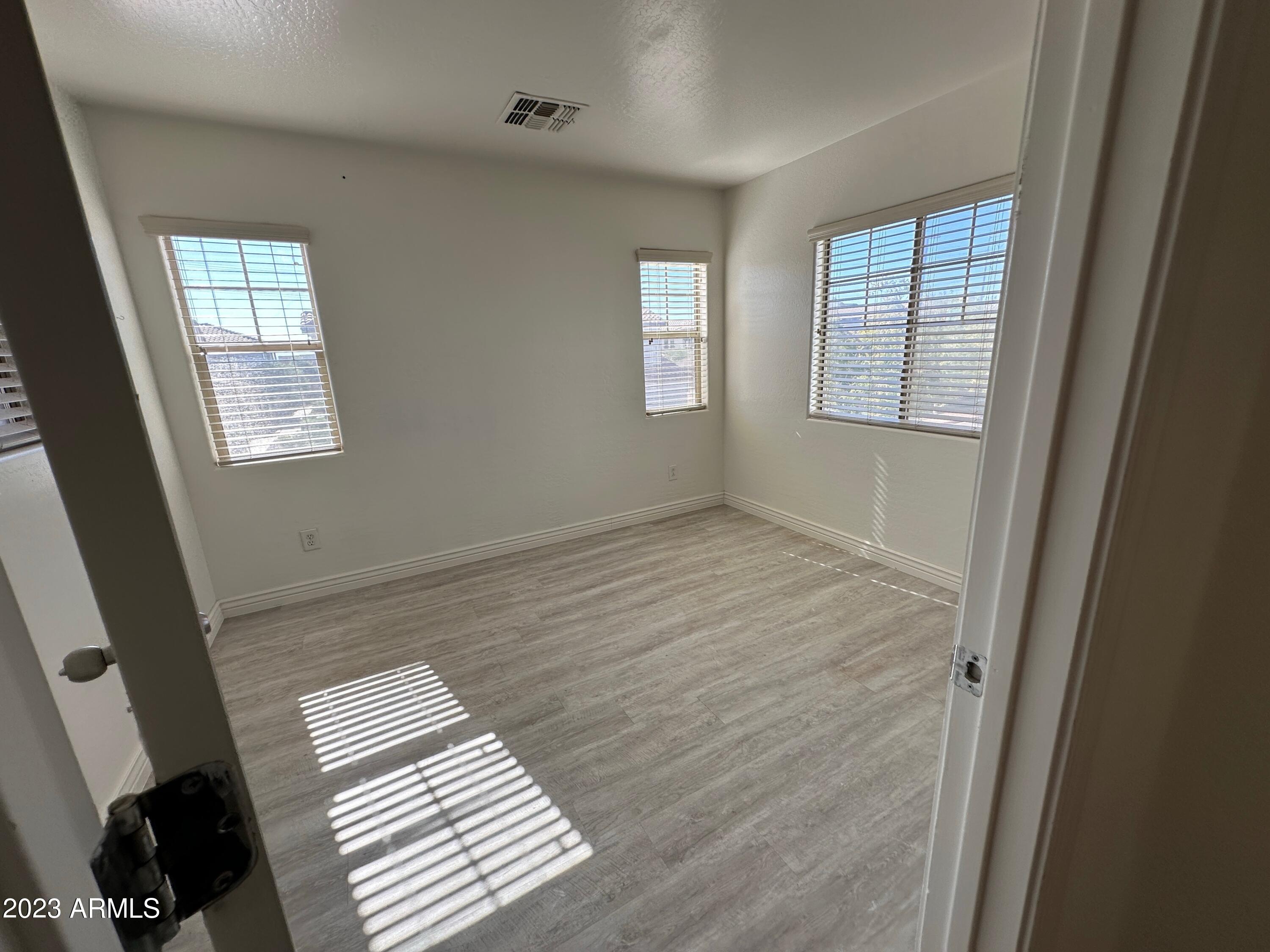 4734 East Olney Avenue Gilbert, AZ 85234 - Photo 15 of 26 a view of an empty room with wooden floor and a window