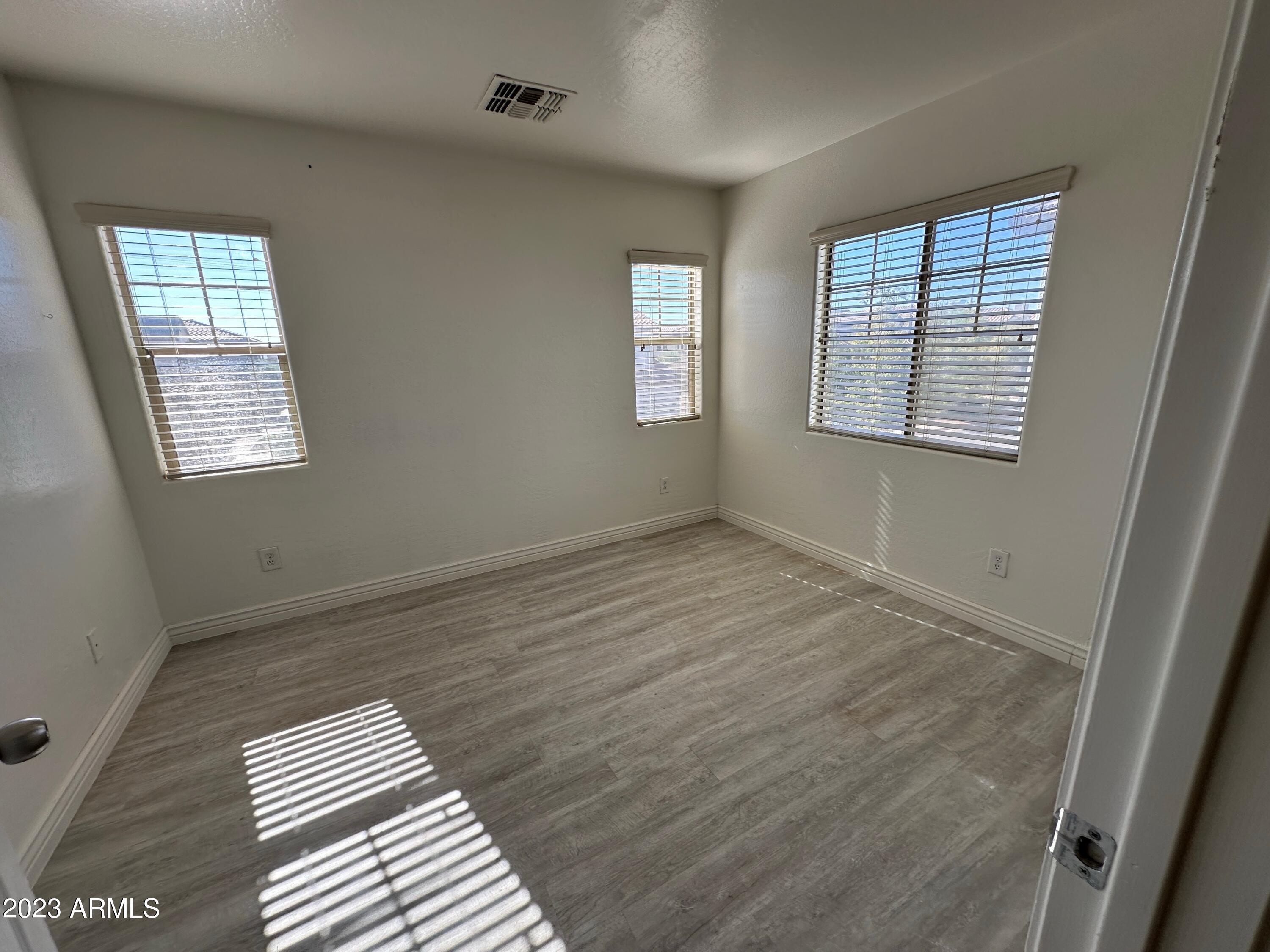 4734 East Olney Avenue Gilbert, AZ 85234 - Photo 16 of 26 a view of an empty room with wooden floor and a window