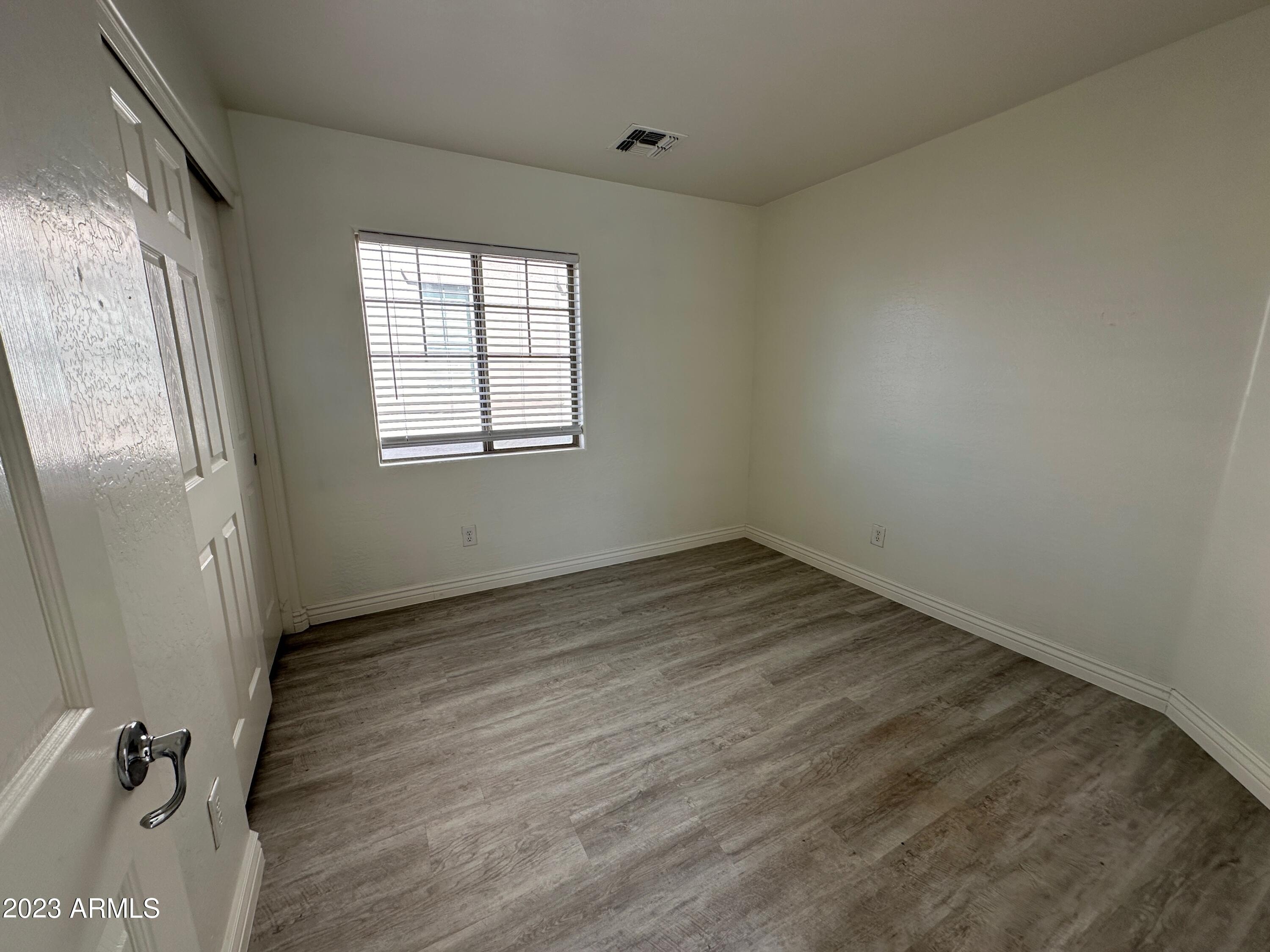 4734 East Olney Avenue Gilbert, AZ 85234 - Photo 18 of 26 an empty room with wooden floor and windows