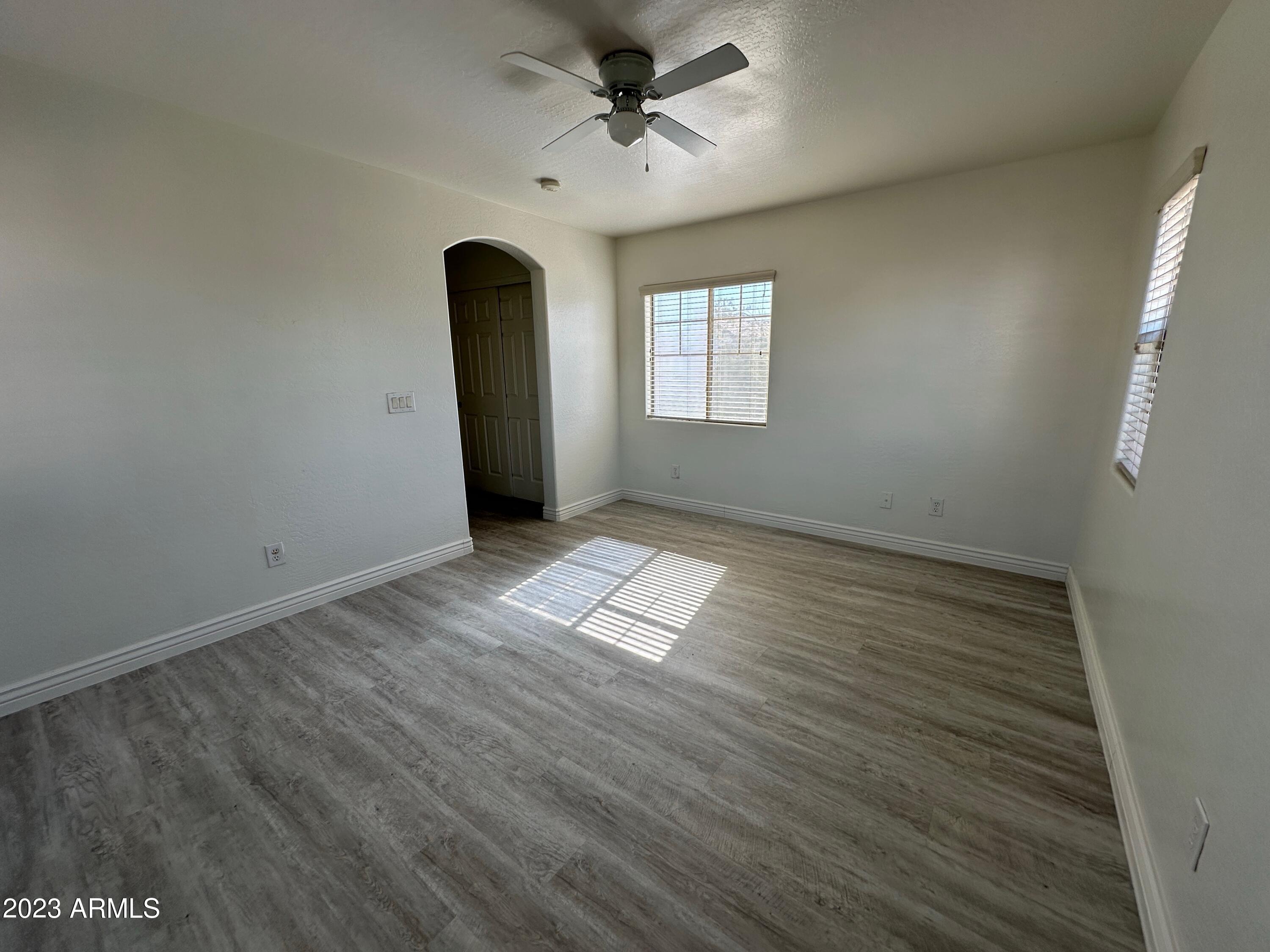 4734 East Olney Avenue Gilbert, AZ 85234 - Photo 21 of 26 an empty room with wooden floor and windows