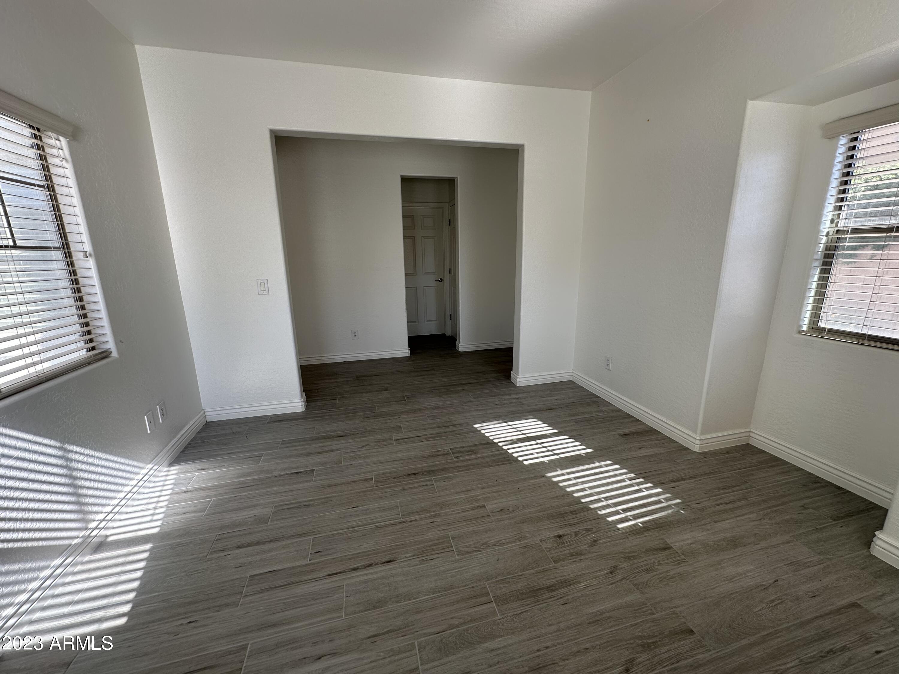 4734 East Olney Avenue Gilbert, AZ 85234 - Photo 4 of 26 an empty room with wooden floor and windows