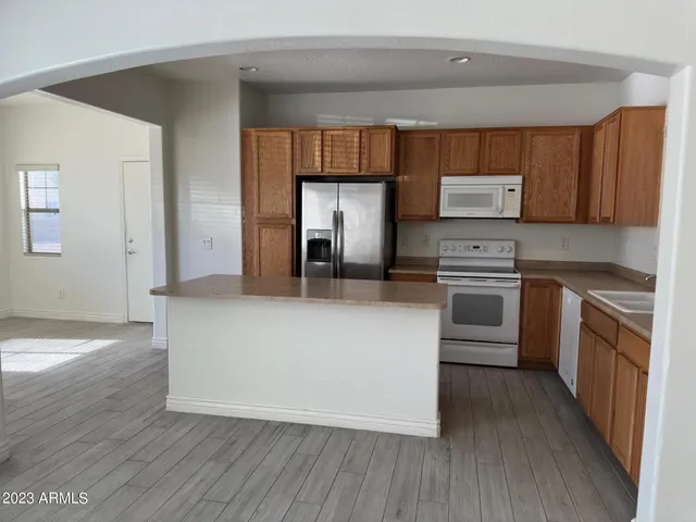 a kitchen with stainless steel appliances a stove top oven a sink and a refrigerator