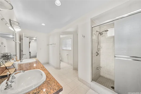 a bathroom with a tub shower sink and mirror