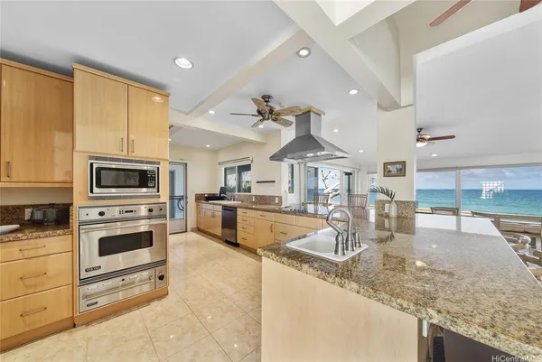 a kitchen with stainless steel appliances granite countertop a stove a sink and a microwave