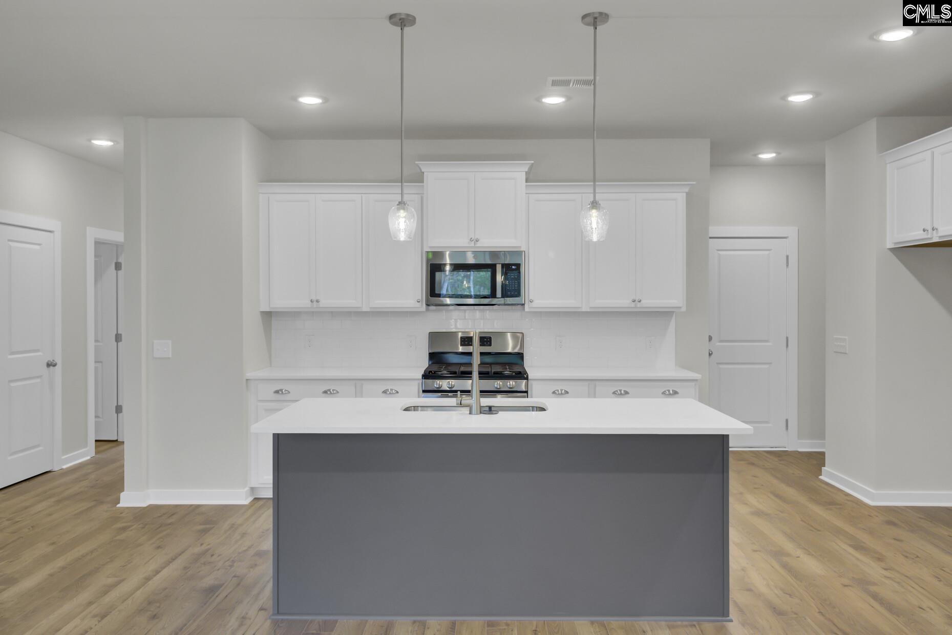 320 Brass Billion Path Lexington, SC 29073 - Photo 12 of 39 a kitchen with kitchen island a sink stainless steel appliances and white cabinets