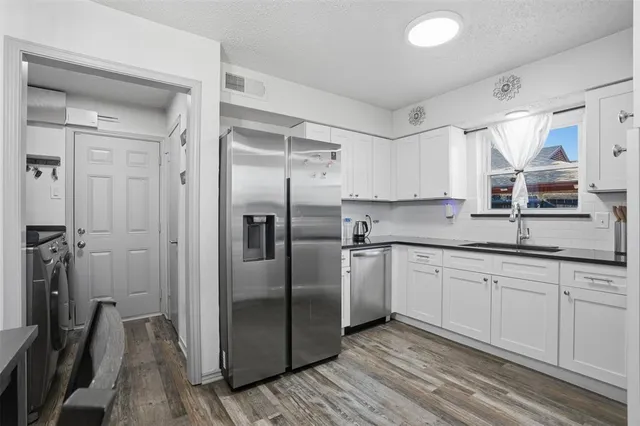 a kitchen with stainless steel appliances granite countertop a refrigerator and a sink