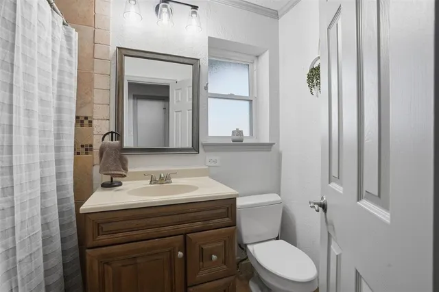 a bathroom with a toilet a sink and mirror