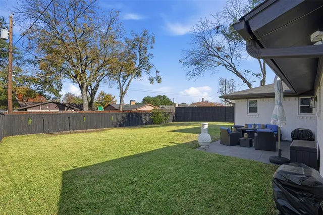 a view of a backyard with couches plants and large tree