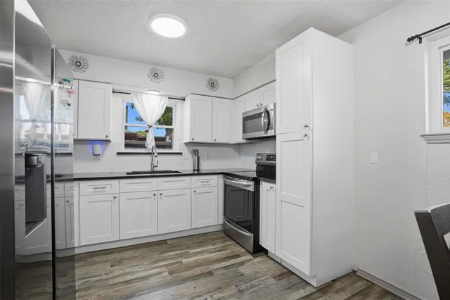 a kitchen with stainless steel appliances granite countertop a refrigerator and a sink