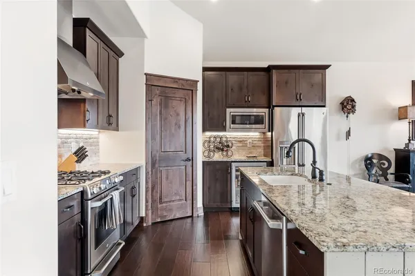 a kitchen with stainless steel appliances granite countertop a sink stove and refrigerator