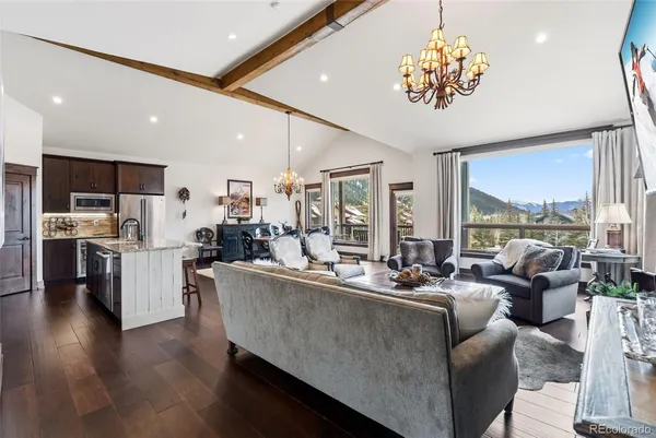 a living room with stainless steel appliances kitchen island furniture and a large window