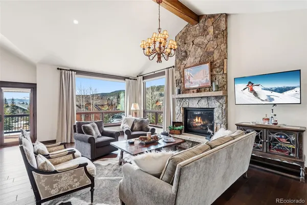 a living room with furniture a fireplace and a floor to ceiling window