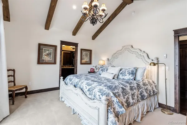 a bedroom with a large bed and a chandelier