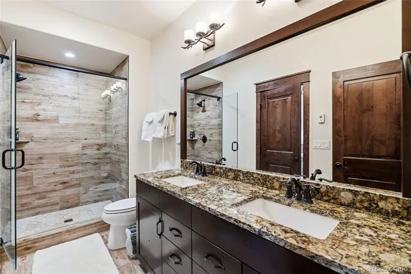 a bathroom with a granite countertop sink toilet and shower