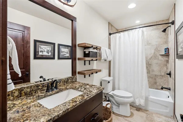 a bathroom with a granite countertop sink toilet and shower