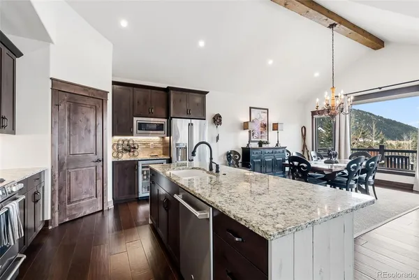 a kitchen with stainless steel appliances granite countertop a sink refrigerator and cabinets