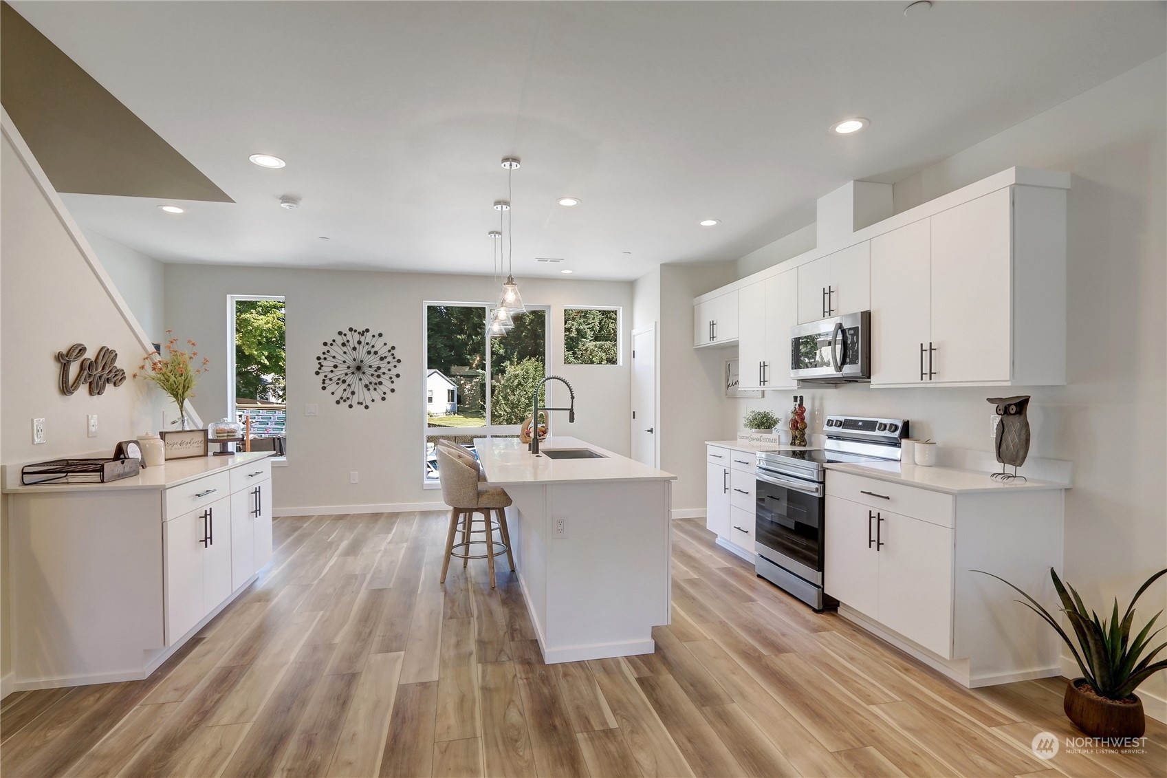 2527 Gibson Road, Unit A6 Everett, WA 98204 - Photo 8 of 24 a kitchen with stainless steel appliances a white stove top oven a sink dishwasher and a dining table with wooden floor