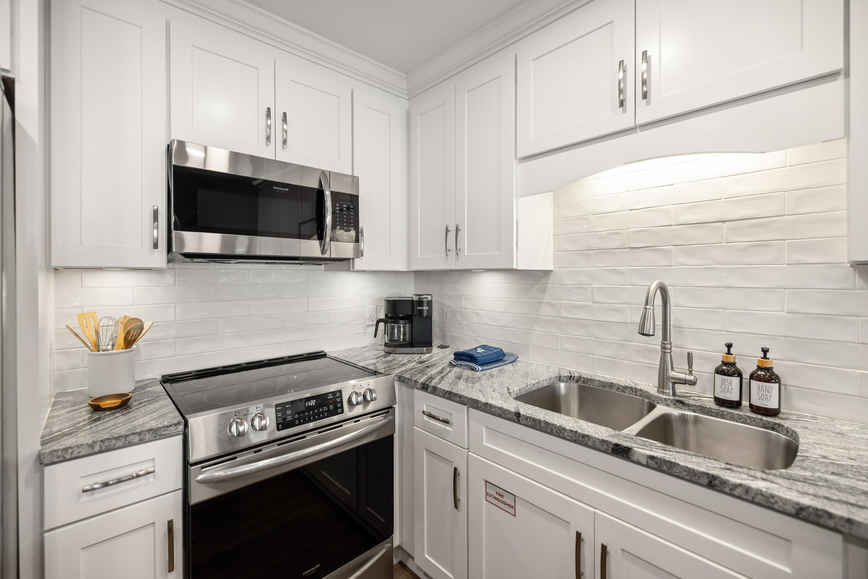 17670 Front Beach Road, Unit L7 Panama City Beach, FL 32413 - Photo 14 of 69 a kitchen with stainless steel appliances granite countertop a sink a stove and a microwave