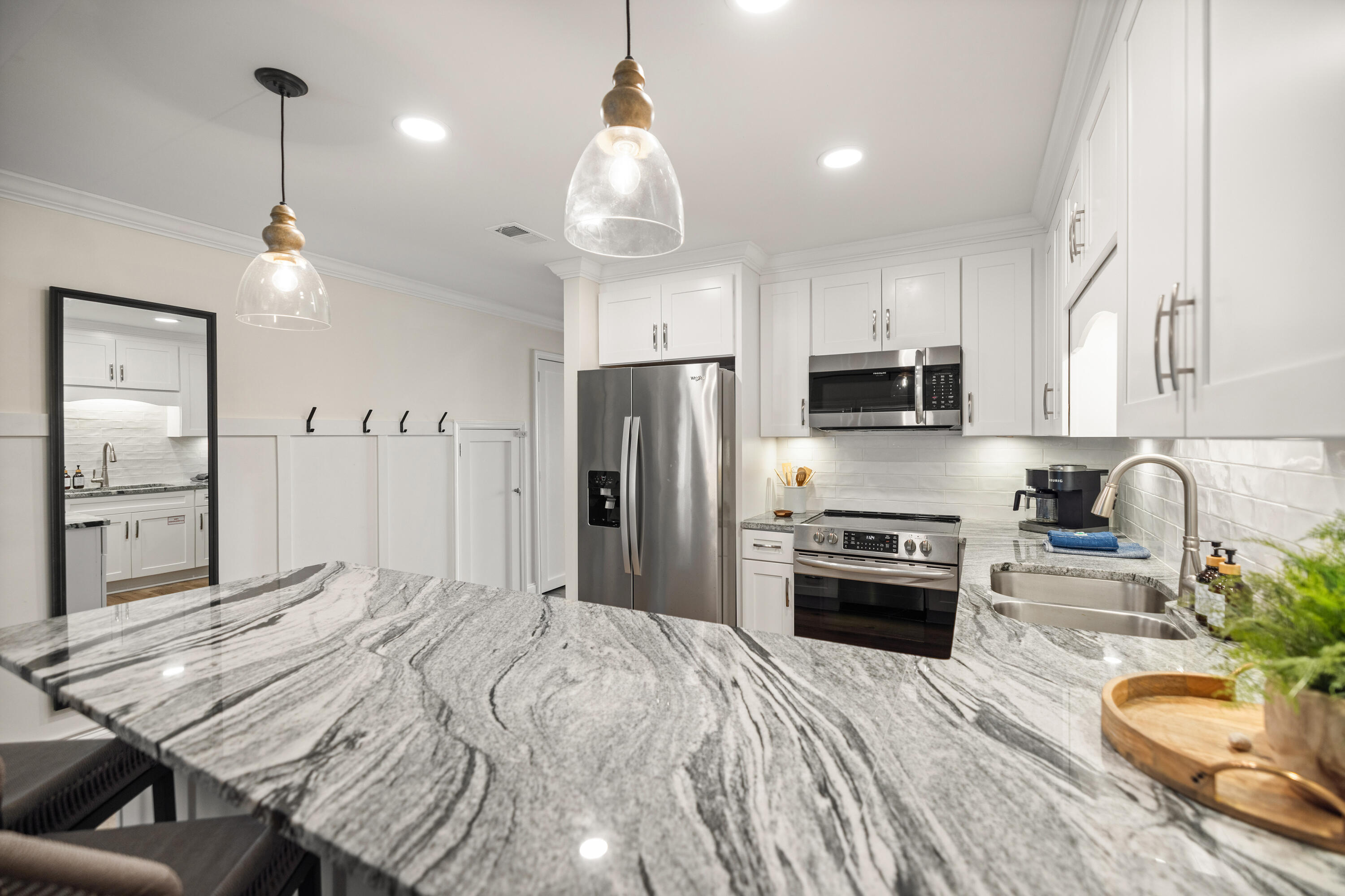 17670 Front Beach Road, Unit L7 Panama City Beach, FL 32413 - Photo 16 of 69 a kitchen with stainless steel appliances granite countertop a refrigerator a stove and a sink dishwasher with wooden floor