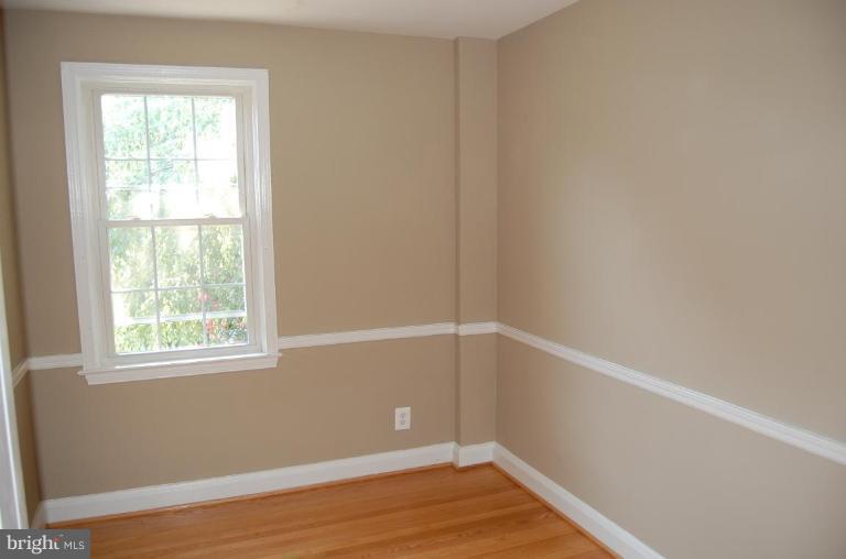 135 Stanmore Road Baltimore, MD 21212 - Photo 23 of 30 an empty room with wooden floor and windows