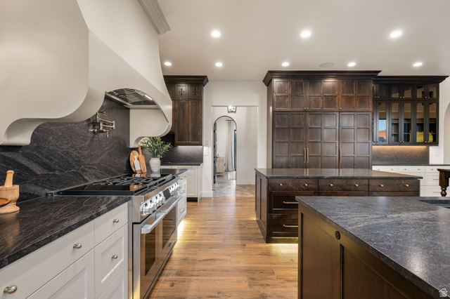 4871 South Homestead Way Washington, UT 84780 - Photo 28 of 151 Kitchen featuring backsplash, dark wood finish cabinets, range with two ovens, arched walkways, and recessed lighting