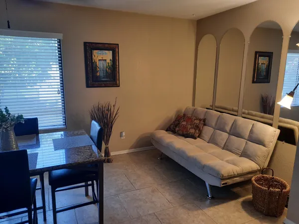 a bedroom with a bed ceiling fan and a lamp on a table