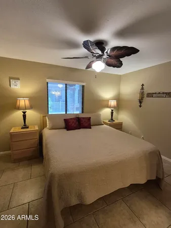 a large bedroom with a bed and window with lamp