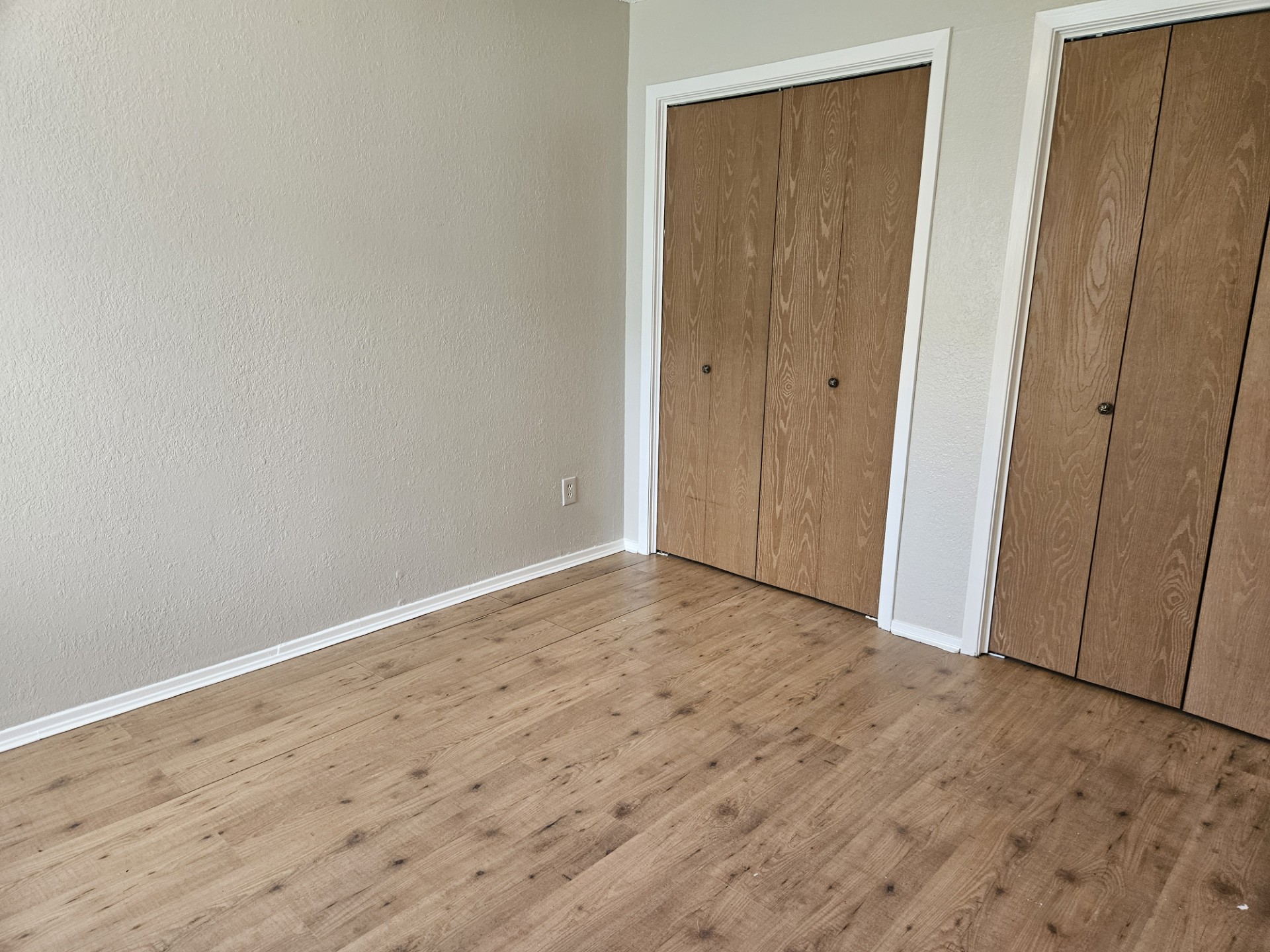 805 Lexington Road, Unit B Elgin, TX 78621 - Photo 8 of 11 Laminate wood flooring grounds this naturally lit bedroom, featuring dual closets with ample storage.