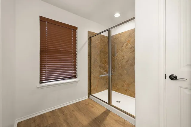 a bathroom with a shower and a glass door