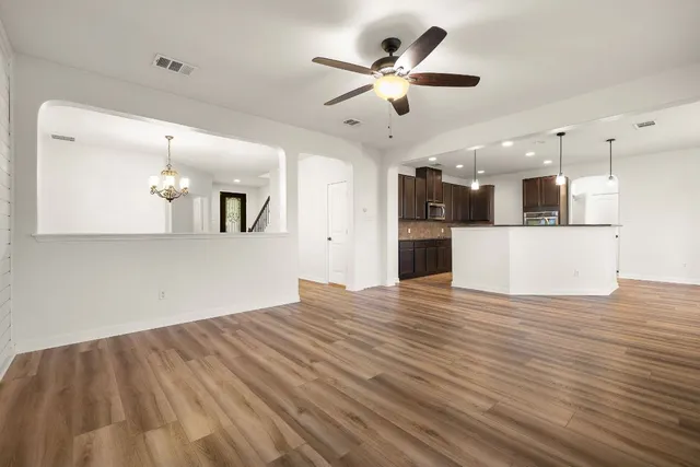 wooden floor in an empty room with a kitchen