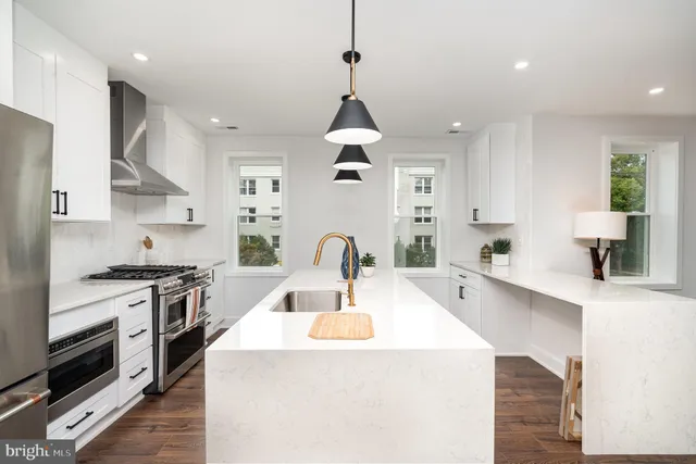 a kitchen with stainless steel appliances kitchen island a stove a sink a refrigerator and cabinets