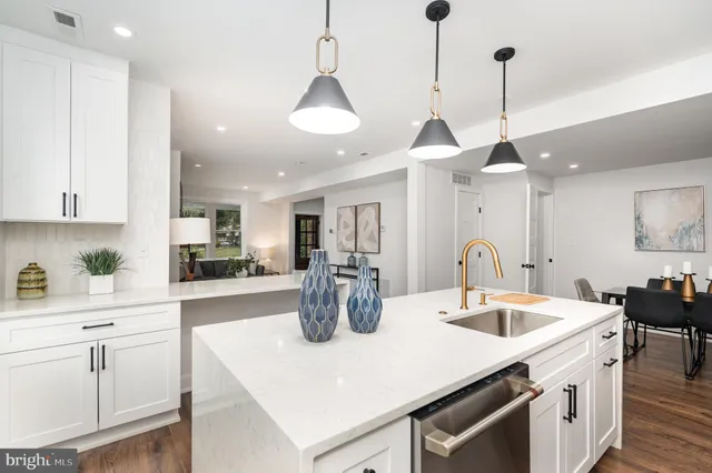 a kitchen with a sink a center island and cabinets