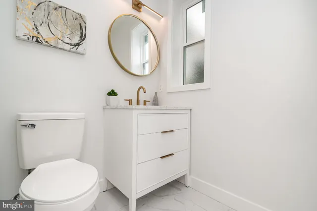 a bathroom with a toilet a sink and a mirror