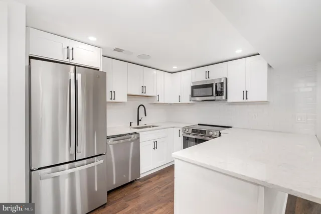 a kitchen with appliances a sink and a refrigerator