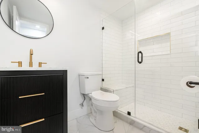 a bathroom with a sink a toilet and a mirror