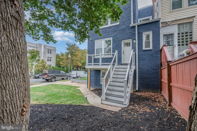 a view of a house with backyard and a tree