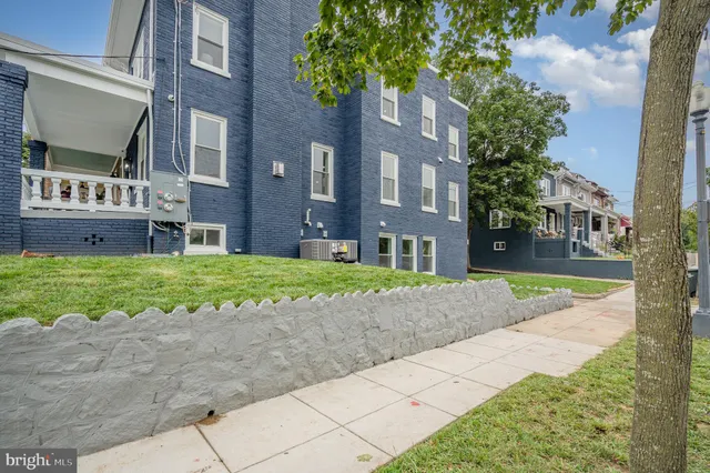 a view of a brick building next to a yard