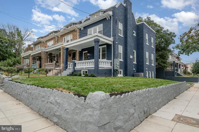 a front view of a house with a yard and plants