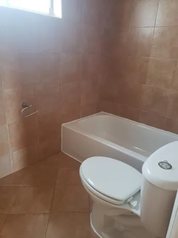 a white toilet sitting next to a bath tub