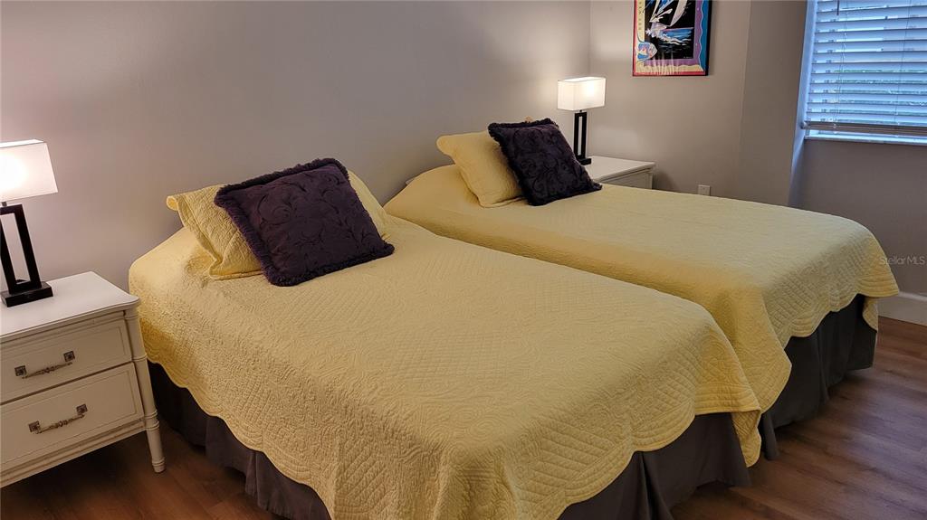 2938 Clark Road, Unit 104 Sarasota, FL 34231 - Photo 13 of 18 a large bed sitting in a bedroom next to a lamp