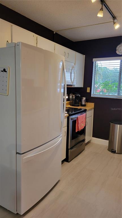 2938 Clark Road, Unit 104 Sarasota, FL 34231 - Photo 2 of 18 a kitchen with stainless steel appliances a refrigerator and a stove